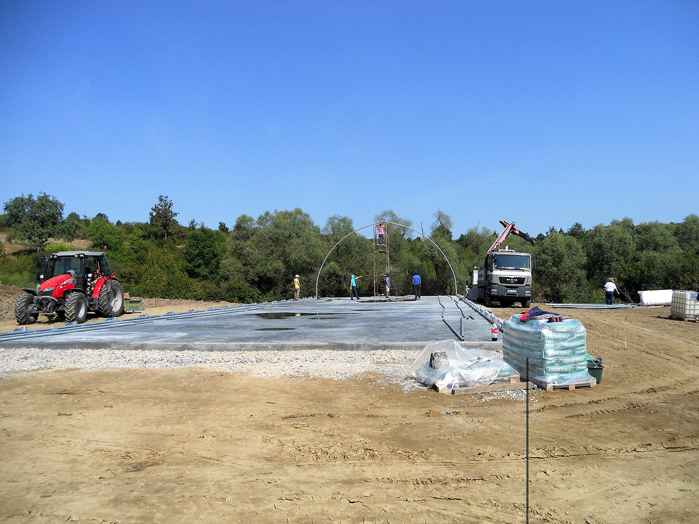 Die ersten Rundbögen werden auf dem Betonfundament montiert Die ersten Rundbögen werden auf dem Betonfundament montiert